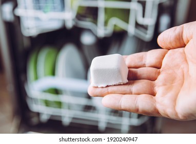 Selective focus on woman hand, holding homemade natural dishwasher pod defocus dishes in dishwasher on background. Green sustainable lifestyle concept. - Powered by Shutterstock