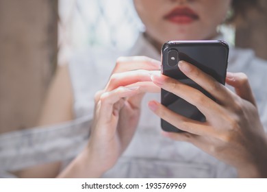 Selective focus on Young woman hand while using  mobile smart phone by texting the message to communicate with someone, surf the internet, buy product online shopping, copy space, modern technology