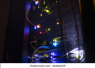 Selective focus. Operating network equipment in the server room. Processing the data stream on the optical channel. Data center in the dark. 