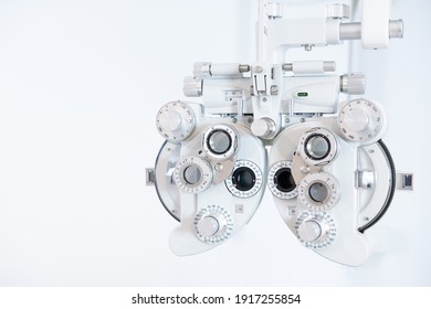 Selective Focus At Optometry Frame Equipment. With Blurred White Background For Copy Space. Optometrist Tool To Examine Eye Visual System Of Patient With Professional Machine Before Made Glasses. 