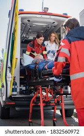 Selective Focus Of Paramedic Carrying Stretcher With Patient Near Doctor With Digital Tablet In Ambulance Car