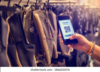 Selective focus to payment QR code tag on smartphone with blurry many cloth shoes in the store to accepted generate digital pay without money. Qr code payment concept.