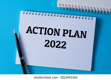 Selective Focus Of Pen And Notebook Written With ACTION PLAN 2022 On Blue Background.