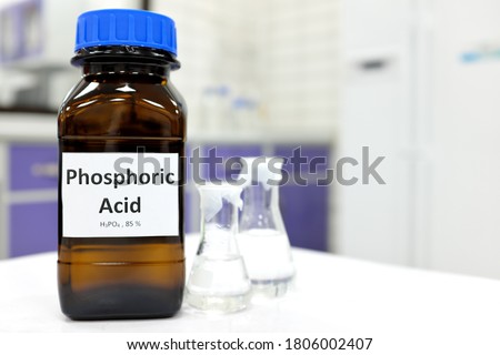 Selective focus of Phosphoric acid solution in brown amber bottle. Blur white laboratory backdrop with copy space.	