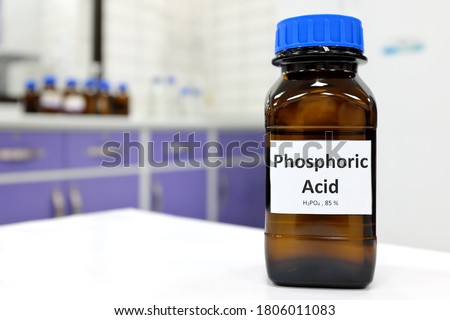 Selective focus of Phosphoric acid solution in brown amber bottle. Blur white laboratory backdrop with copy space.	
