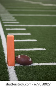 Selective Focus Photo Of The Pylon And Touchdown Line On A Football Field. Low Angle View From The End Zone In An Indoor Stadium