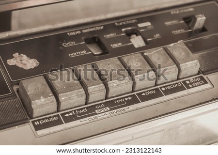 Selective focus photo of Silver Old Radio tape recorder radio pause forward cut rewind play record buttons. Vintage, Unique, Rare collector item, collection, museum, old fashioned, cassette tape.