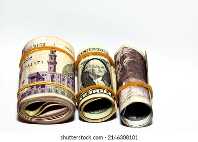 Selective focus of pile of Pile of American dollars rolls with rolled up Egyptian money banknote bills of 100 LE, 200 LE one hundred and two hundred pounds, USA dollar and Egyptian pound exchange rate