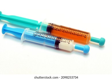 Selective focus of plastic oral syringes to administer medications, drugs, and liquids for newborn, babies and kids isolated on white background, medical syringes 10 ml with white and brown therapy 