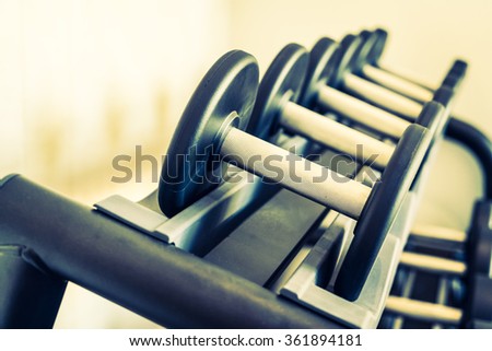 Selective focus point on Dumbbell equipment in fitness gym - Vintage filter