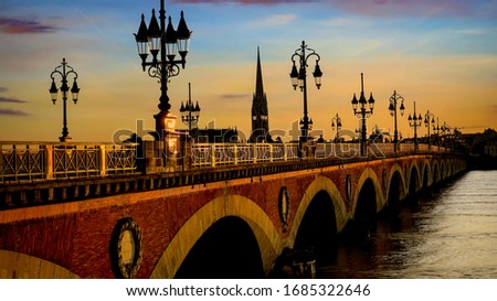 Selective focus of  Pont de Pierre bridge and motion blur of tram in Bordeaux at sunset as the night sky scene