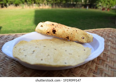 Selective Focus Of Popular Indian Savoury Snack Eaten With Lunch Dinner Or Just Snacks. Papad Or Pappadoms. Both Roasted And Deep Fried Papads Served In White Plate