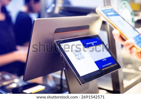 Selective focus to POS Machine with blurry customer scan QR code to payment and receipt at cash register machine in cafe or restaurant.