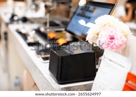 Selective focus to printer of POS set with blurry computer. Point of sale system for retail stores or restaurants. Receipt printer to shopping invoice and touch screen display.