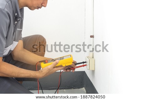 Selective focus of probes of digital multimeter with socket outlet, Digital multimeter in hands of electrician measuring volttage in a socket for detecting faults and safety before starting work
