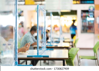 Selective focus of PVC pipe is attached to clear plastic sheet placed on table to prevent spread of virus (coronavirus,covid-19) in cafeteria and canteen. Social distancing concept.