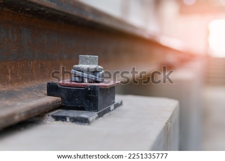 Selective focus of rail and fastener in depot on viaduct of sky train which has rail Fastener for hold rail with concrete slab track.