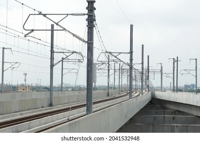 Selective focus railway electrification system above tracks. Overhead catenary, mast, bracket, insulator, catenary wires, feeder installed. Electric train system concept.