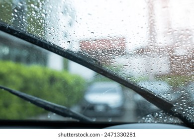 Selective focus to rain droplet with motion blurry wiper on windshield. Motion blurry windshield wipers from inside of car, season rain. - Powered by Shutterstock