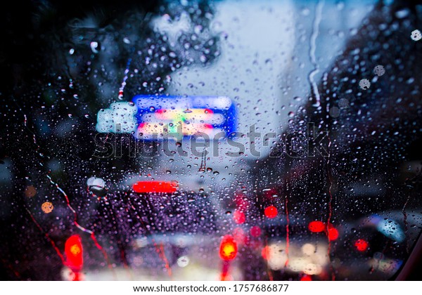 Selective focus to rain droplet on\
windshield with bokeh. View from inside of car, season\
rain.
