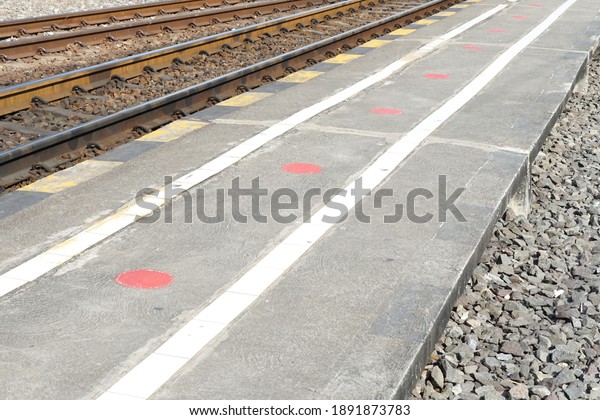 Selective\
focus, red marks on railway platform for inform passenger standing\
keeping social distance for safe travel, stop spreading covid-19.\
Social distancing, signs, safe travels\
concept.