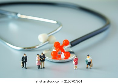 Selective Focus Of Red Virus On Black Stethoscope And Miniature People With Mask On White Ground To Solution For Annual Health Check Up.