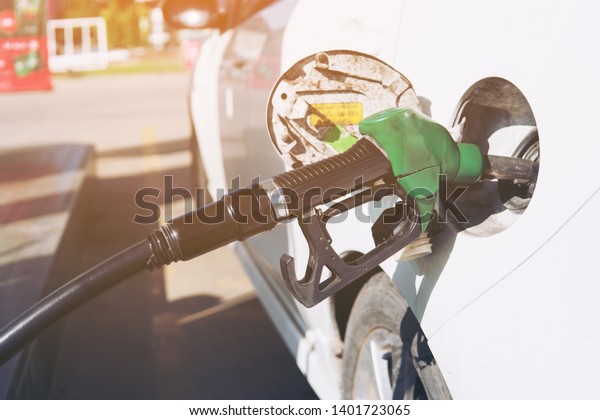 Selective focus Refueling the car\
with super grade petrol at a gas station. Man driver hand refilling\
and pumping  petrol oil the car with fuel at he refuel\
station.