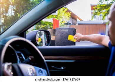 Selective focus to RFID reader with blur driver use key card to open the door for safety. Driver hold card to scan at RFID card reader station for open the car park door. Security system for parking.