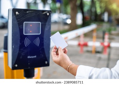 Selective focus to RFID reader with blurry RFID card in hand of driver for automatic barrier gate system. Parking and automatic payment system with licence plate recognition. RFID Concept.