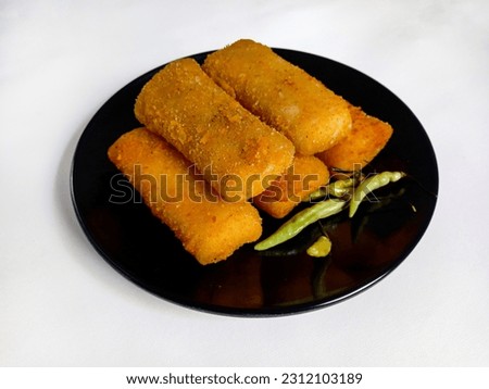 Selective focus risoles sosis mayo (American risoles) or mayonnaise sausage rissole is a small patty rolled in breadcrumbs. it is filled with mayonnaise, boiled egg and sausage. Served on black plate.