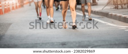 Selective focus to road surface with blurry human foot marathon race on city streets. Human foot marathon race on city streets.
