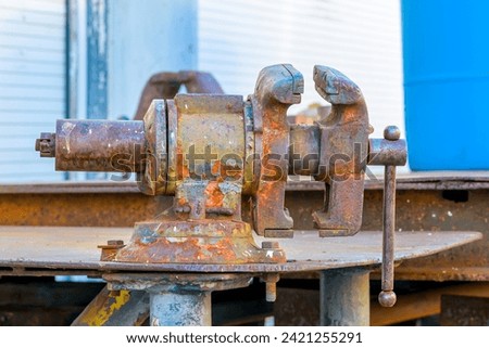 Selective focus of a rusted, heavy metal vice on outdoor work bench in New Orleans, LA, USA