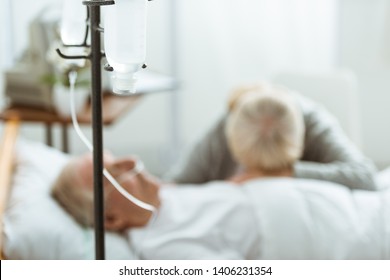 Selective Focus Of Sad Senior Woman With Husband In Coma In Clinic