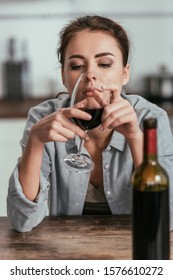 Selective Focus Of Sad Woman Looking On Wine Glass