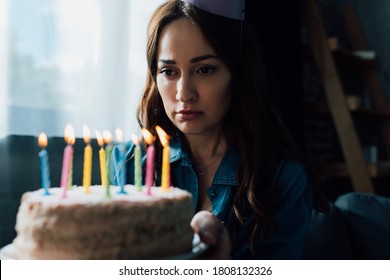 Selective Focus Of Sad Woman Looking At Birthday Cake With Candles