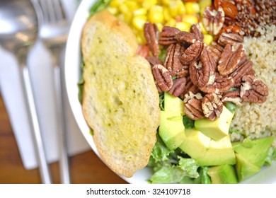 Selective Focus Of Salad Bowl With Avocado, Almond, Quinoa And Garlic Bread