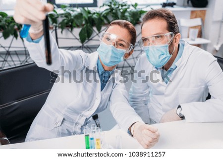 selective focus of scientists looking at reagent in laboratory