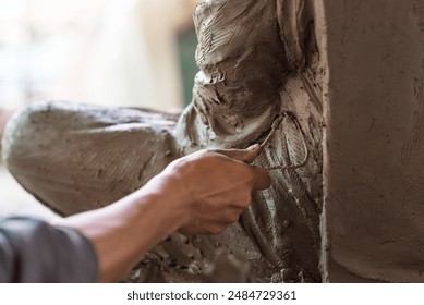 Selective focus sculptor hand molding clay.Professional artist worker creating a statue sculpture with wet clay.Handicraft production. - Powered by Shutterstock