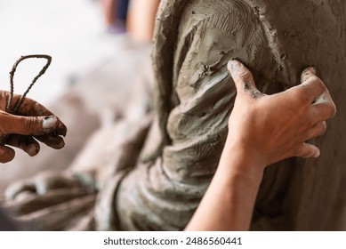 Selective focus sculptor hand molding clay.Professional artist worker creating a statue sculpture with wet clay.Handicraft production. - Powered by Shutterstock