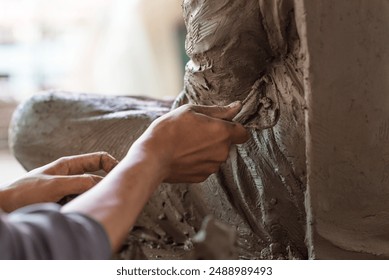 Selective focus sculptor hand molding clay.Professional artist worker creating a statue sculpture with wet clay.Handicraft production. - Powered by Shutterstock