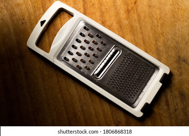 a selective focus shot of a cheese shredder on a woodern surface  - Powered by Shutterstock