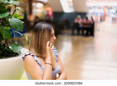 A Selective Focus Shot Of An European Caucasian Young Girl Talking On Her Smartphone Distracted Not Paying Attention To Anything In A Shopping Mall