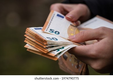 A selective focus shot of a female hand counti euro banknotes - Shutterstock ID 1974790775