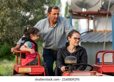 Selective Focus Shot Of Grandfather, Daughter And Grand Daughter On Tractor Ride.