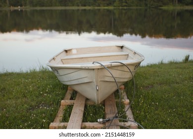 A selective focus shot of the rowboat docked on the grassland near the lake