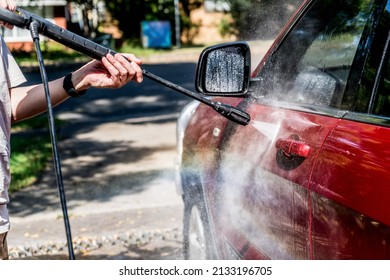Selective focus shot of washing a red Suv 4wd car with high pressure washer cleaner. Car wash. Rainbow water drops - Shutterstock ID 2133196705