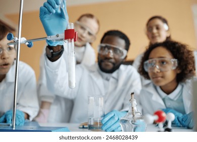 Selective focus shot of young Black teacher and group of ethnically diverse kids doing laboratory experiment in Chemistry class - Powered by Shutterstock