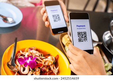 Selective focus to smartphone in hand to scan QR code on tag with blurry spicy Thai food. Customers in restaurant to accepted generate digital pay without money. Qr code payment concept.