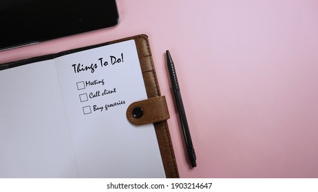 Selective Focus Of A Smartphone, Pen And Diary Written With Things To Do Checklist On Pink Background