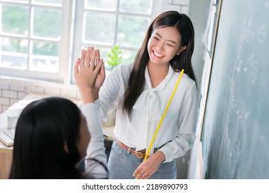 Selective Focus Of Smiling Asian Teacher Woman Teaching Student In English Classroom, Female Teacher Writing On Blackboard, High School And Back To School Concept.